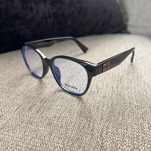 Miu Miu MU 02VV eyeglasses in black acetate with blue inner rims and gold accent